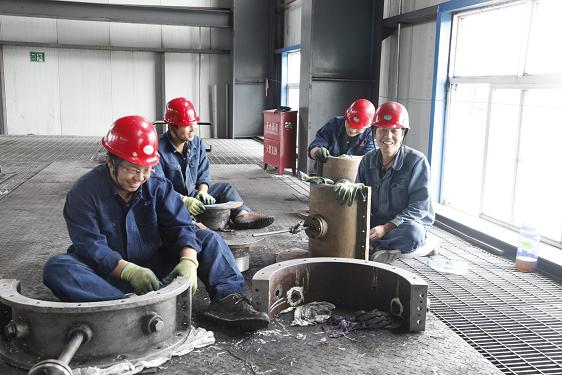 離心壓縮機的檢修是一項精細而又繁重的工作。檢修車間工作人員和制氫車間姬智裕等正在清理設備零件。